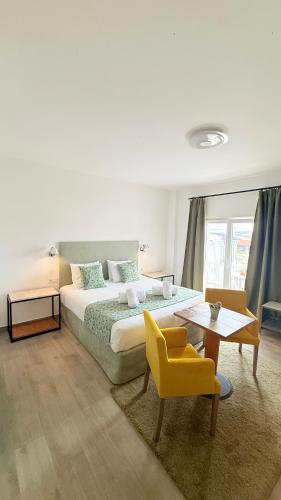 a bedroom with a bed and a table and a chair at O Tourinho Ferrel in Ferrel
