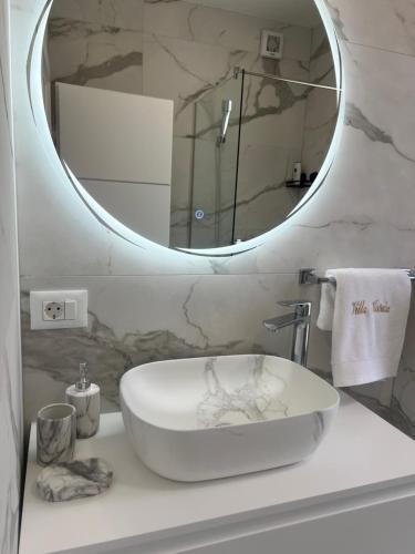a bathroom with a white sink and a mirror at Villa Koćuša in Ljubuški