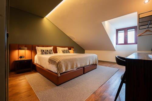 a bedroom with a large bed in a attic at Santo Thyrso Hotel in Santo Tirso