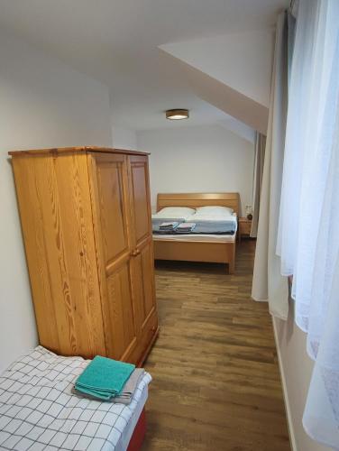 a small room with two beds and a cabinet at Apartmán Štiavnik in Vysoké Tatry