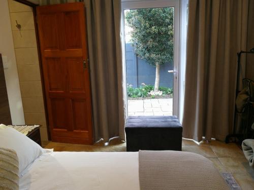 a bedroom with a bed and a sliding glass door at Martin Villa in Somerset West
