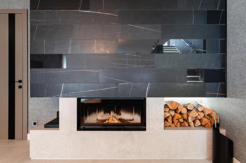 a fireplace with a fire in it with logs at Villa Glam Wellness & Spa Retreat in Mogyoród