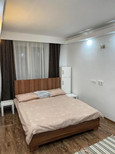 a bedroom with a large bed with a wooden headboard at Alina Home in Mediaş