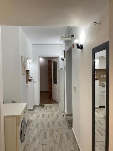 a kitchen with white walls and a tile floor at Alina Home in Mediaş