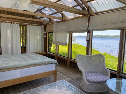a bedroom with a bed and a chair on a deck at Lappnäs Bed & Breakfast in Sunne