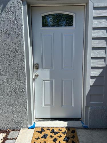 a white front door of a house with a rug at Studio one bed in Clermont