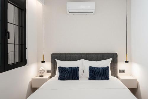 a bedroom with a white bed with two blue pillows at One bedroom Belane Rezident in Tivat