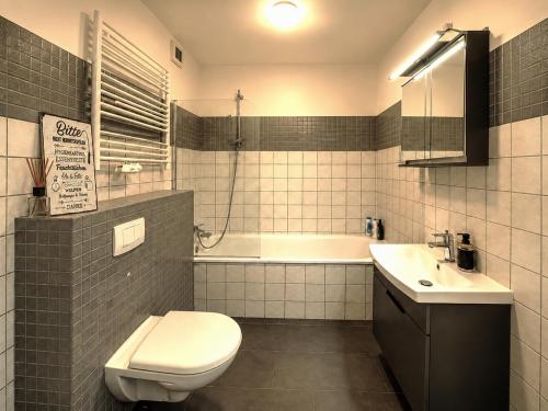 a bathroom with a toilet and a sink and a tub at Apartment Hannover - Langenhagen center in Hannover