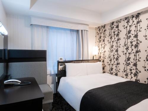 a hotel room with a bed and a desk at APA Hotel Ginza Kyobashi Minami Tokyo Station Yaesu South Gate in Tokyo