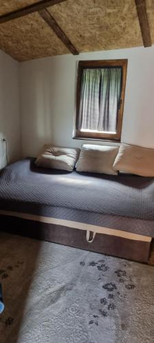 a bed in a room with a window at Planinska kuca Gogo in Kupres