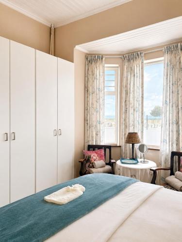a bedroom with a bed and a large window at Oceanfront Escape Beach House in Strand