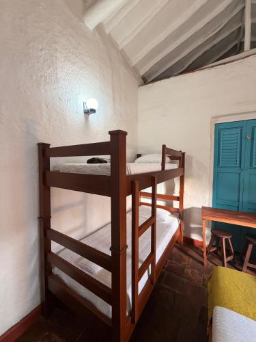 two bunk beds in a room with a table at Habitación Laurel Y Tomillo Independiente in Barichara