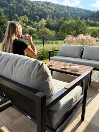a woman drinking a glass of wine on a patio at Osada pod Sokolicą in Krościenko