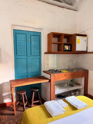 a kitchen with a blue door and a table and stool at Habitación Laurel Y Tomillo Independiente in Barichara