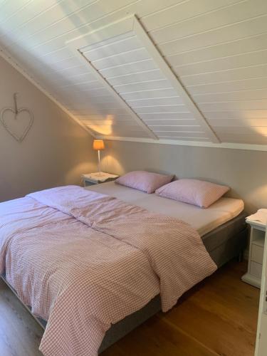 a bedroom with a bed with pink pillows at Mølleråsen Apartment in Sandefjord