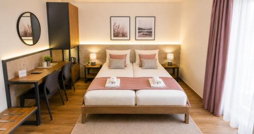 a hotel room with a bed and a desk at Park and Fly Belgrade Airport Apartments in Surčin