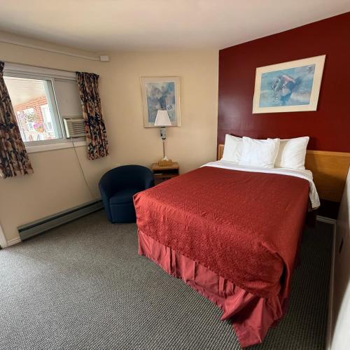 a hotel room with a bed and a chair at Trunk Road Motel in Sault Ste. Marie