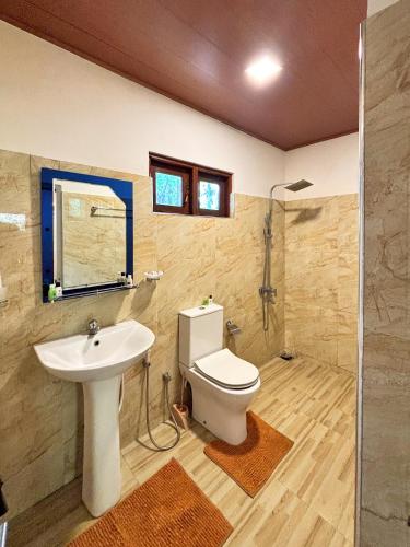 a bathroom with a toilet and a sink at Sigiri Nisala Resort in Sigiriya