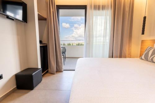 a bedroom with a bed and a view of a balcony at Naiades Guest House in Sálakos