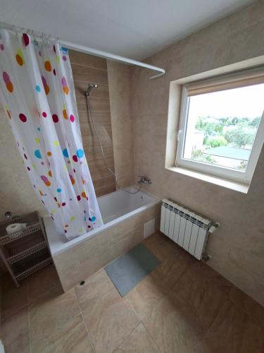 a bathroom with a tub and a shower curtain at Dom na Kościelnej in Ślesin