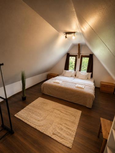 a bedroom with a large bed in a attic at Coco & Simi Lakeside Nest in Cinciş
