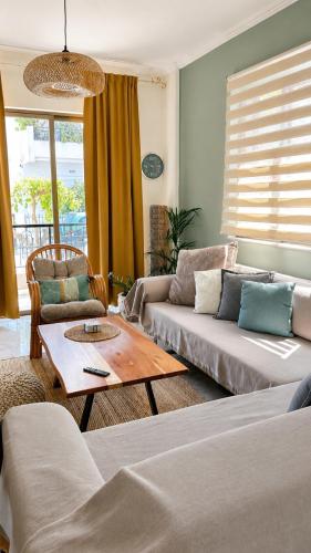 a living room with two couches and a coffee table at Blossom Apartment Kos in Ampavris