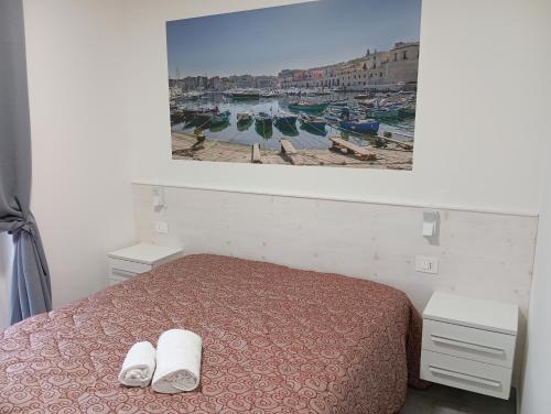 a bedroom with a bed with two towels on it at Villa Maldera-case vacanza-loft- loft queen specchio in Trani
