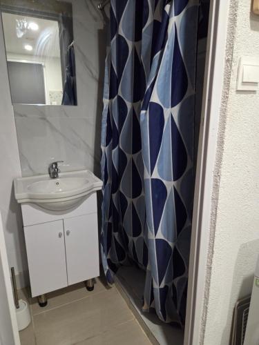a bathroom with a sink and a shower curtain at Ground floor Apt with a garden view in Limassol