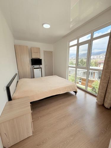 a bedroom with a bed and a large window at Intour in Cholpon-Ata