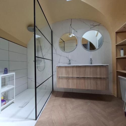 a bathroom with a tub and two mirrors at La Vie Est Belle in Salles-la-Source