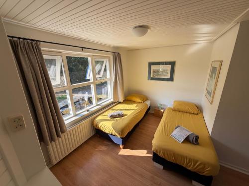 a small room with two beds and a window at B&B Zwiep in Lochem