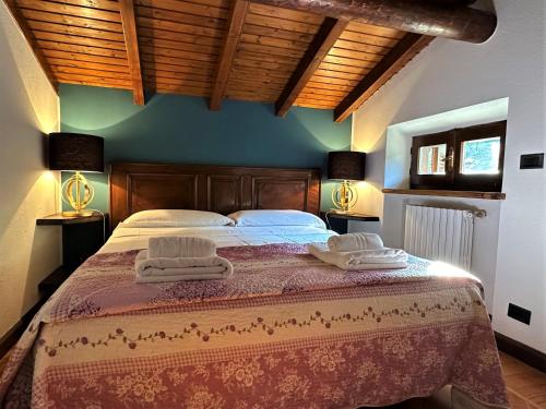 a bedroom with a large bed with two towels on it at L'antica Lodge in Cremia