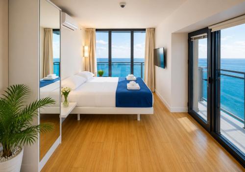 a bedroom with a bed with a view of the ocean at Panorama ORBI CITY LUXURY in Batumi