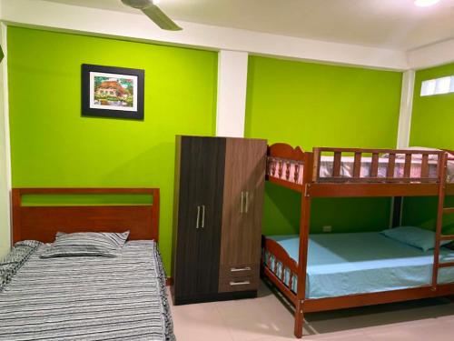 a bedroom with two bunk beds and a green wall at JAARR Alojamientos in Pucallpa