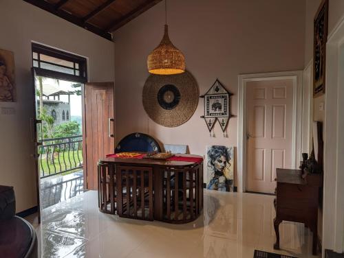 a living room with a table and a door at Rest Harrow Estate in Kandy