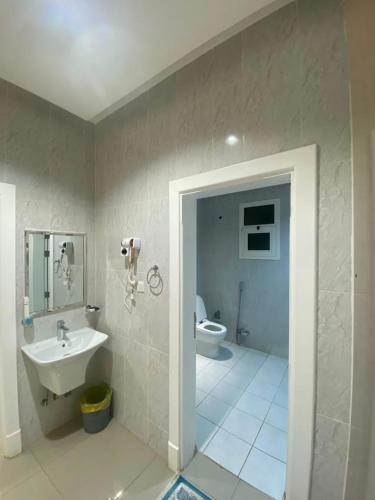 a bathroom with a sink and a toilet at الكادي للشقق المخدومة in Ad Dawādimī