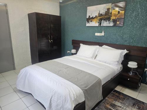 a bedroom with a large bed with white sheets at Domaine Béthania in Tadiénou