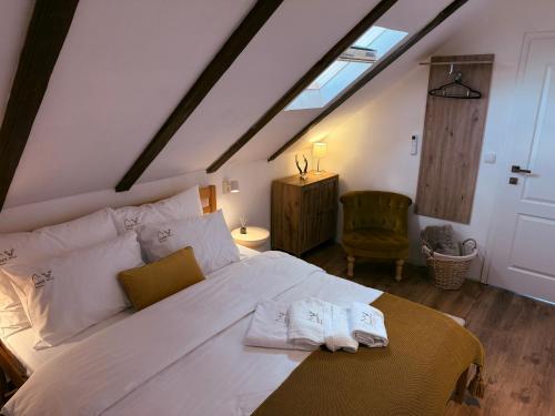 a bedroom with a white bed with two towels on it at Deer Hill in Orahovica