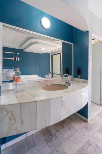 a bathroom with a sink and a large mirror at Acamar Beach Resort in Acapulco