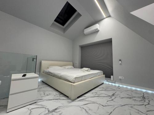 a white bedroom with a bed and a mirror at Kaleju 10 Apartment in Tukums