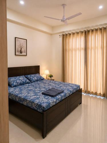 a bedroom with a bed and a ceiling fan at Halfway Home Cozy 2bhk in Rājpur