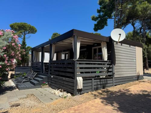 a small house with a black roof at Danyja Mobilehome in Biograd na Moru