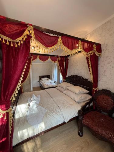 a bedroom with a canopy bed with red curtains at Tadż Mahal Apartament in Sulechów