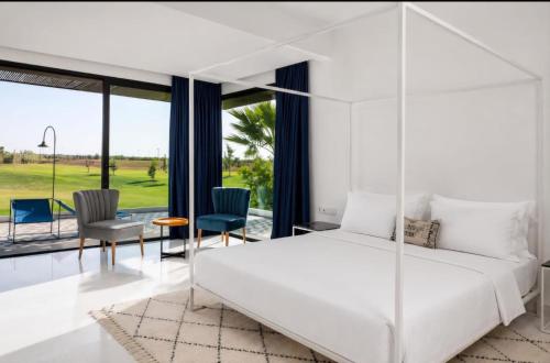 a bedroom with a white bed and a view of a golf course at Luxury Premium Villa Golf Resort Private Pool in Marrakesh