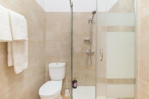 a bathroom with a toilet and a glass shower at Casa Lotus in Aljezur