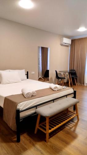 a bedroom with a large bed with a wooden floor at Hotel Aura in Zugdidi