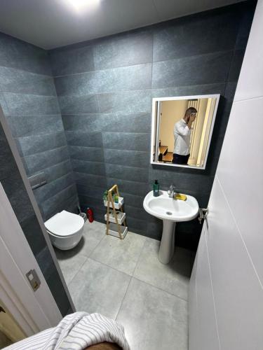 a bathroom with a sink and a toilet and a mirror at Mega Life in Khashmi