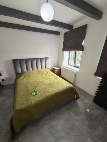 a bedroom with a bed with a green blanket at Mega Life in Khashmi