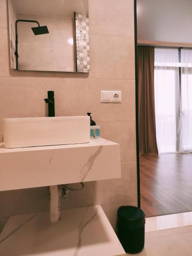 a bathroom with a white sink and a mirror at Hotel Aura in Zugdidi