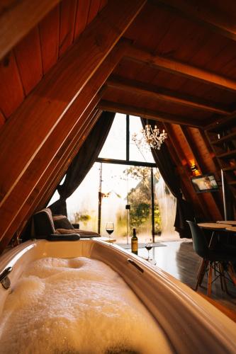 a bath tub in a room with a window at Cabana Amélia, em Gramado in Gramado